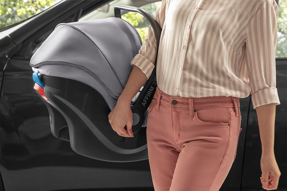 Woman carrying car seat after retouching