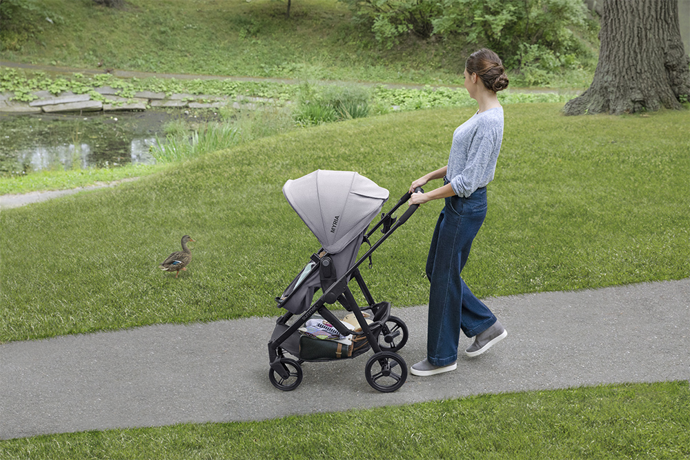 Woman pushing stroller in park after retouching